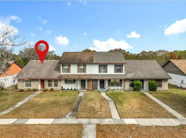 a view of a white house with a swimming pool and a yard