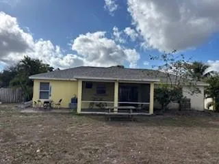 a view of a house with backyard and a large tree