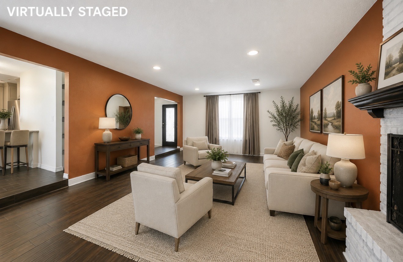 3728 Autumn Lane Baytown, TX 77521 - Photo 5 of 16 Spacious living room with a warm orange accent wall, white brick fireplace, and large window providing natural light. It features recessed lighting and dark wood flooring for a cozy atmosphere.