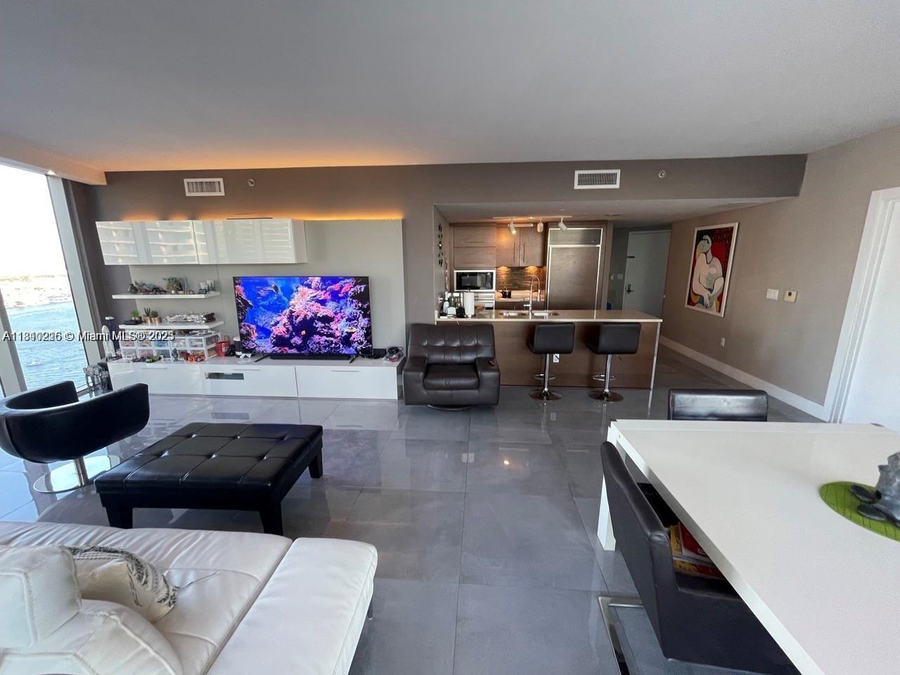 Icon Brickell Miami, FL 33131 - Photo 4 of 12 a living room with furniture and a flat screen tv