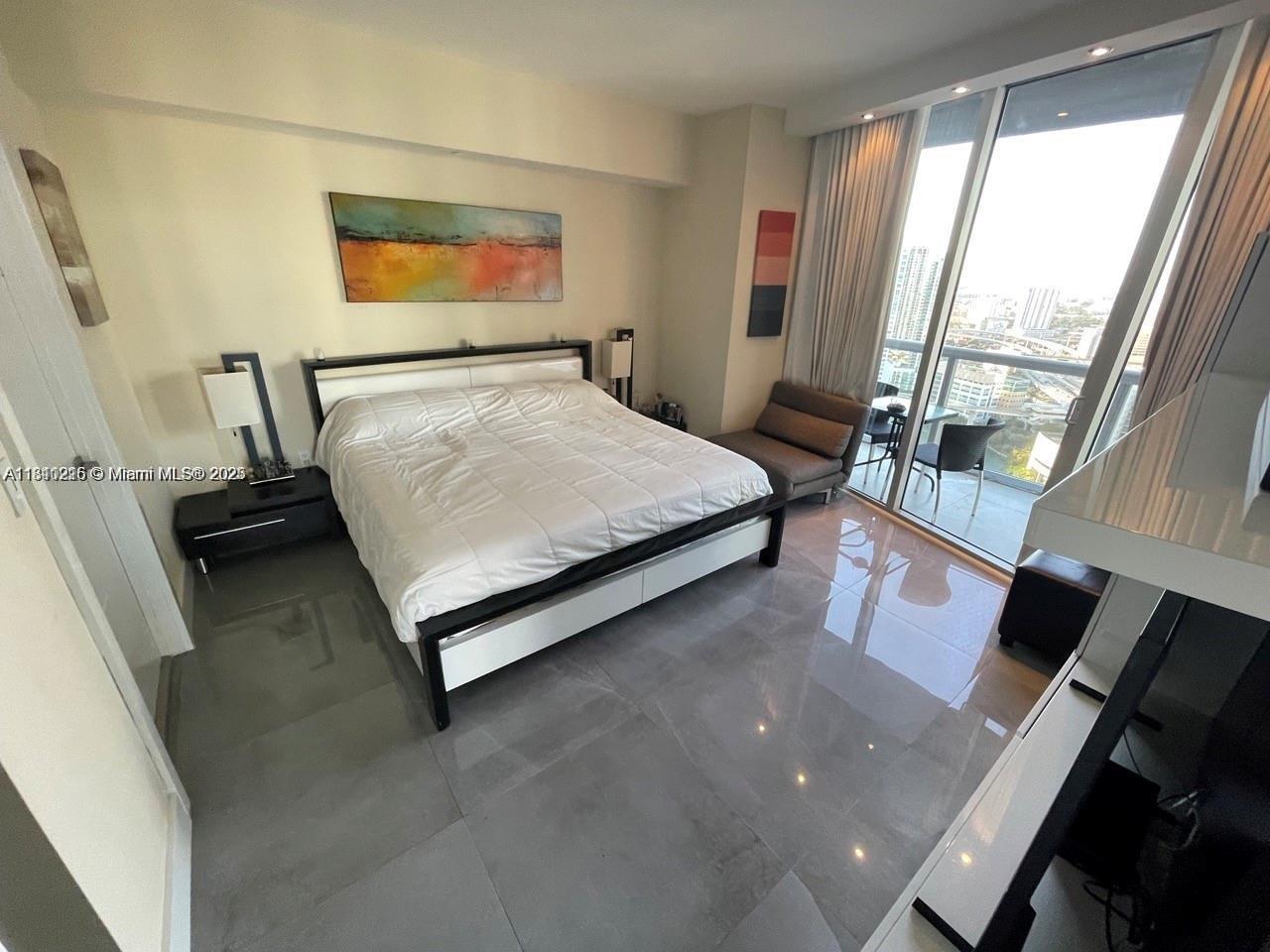 Icon Brickell Miami, FL 33131 - Photo 7 of 12 a bed sitting in a bedroom next to a window