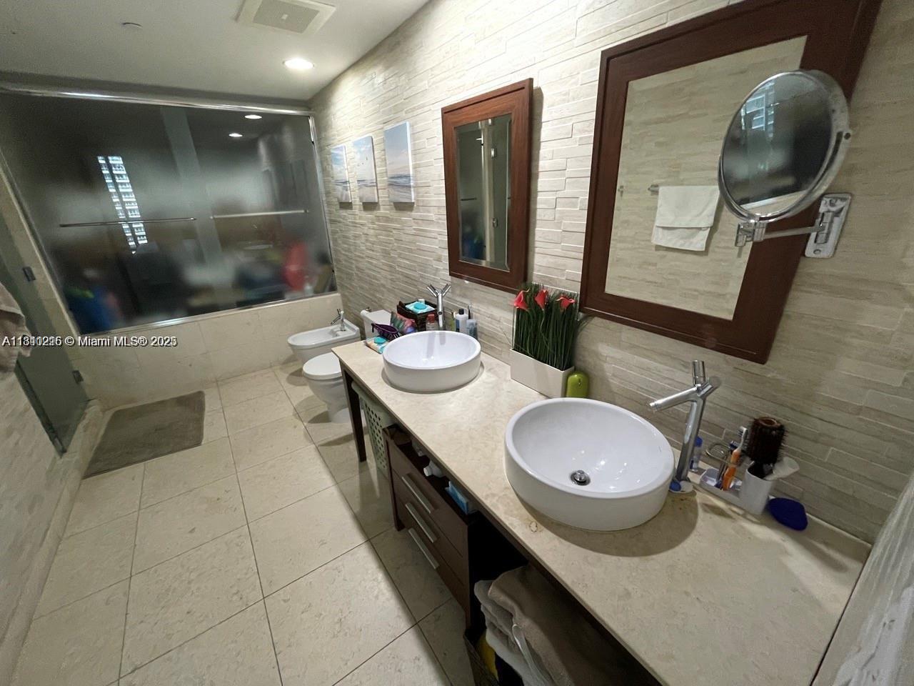 Icon Brickell Miami, FL 33131 - Photo 9 of 12 a bathroom with a double vanity sink and a mirror