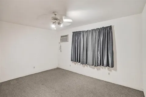 an empty room with closet and a ceiling fan