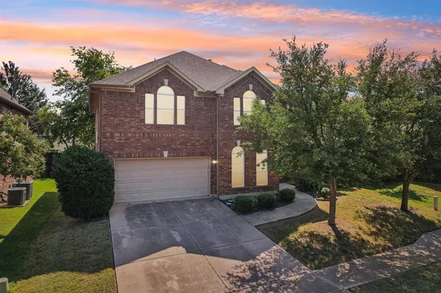 a front view of a house with a yard and trees