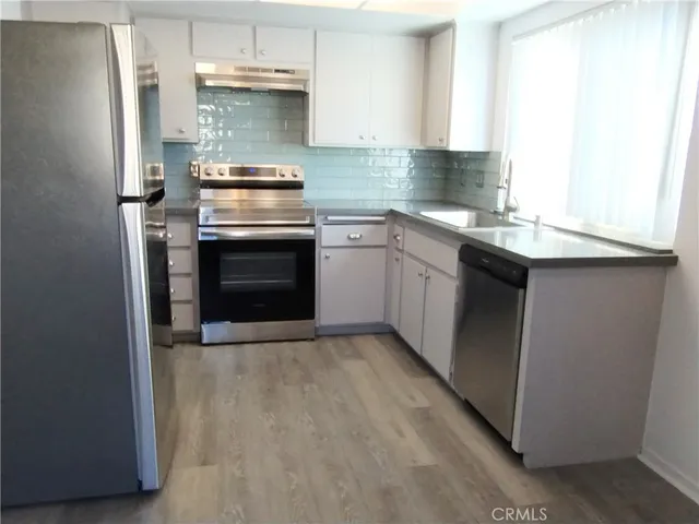 a kitchen with a stove and white cabinets