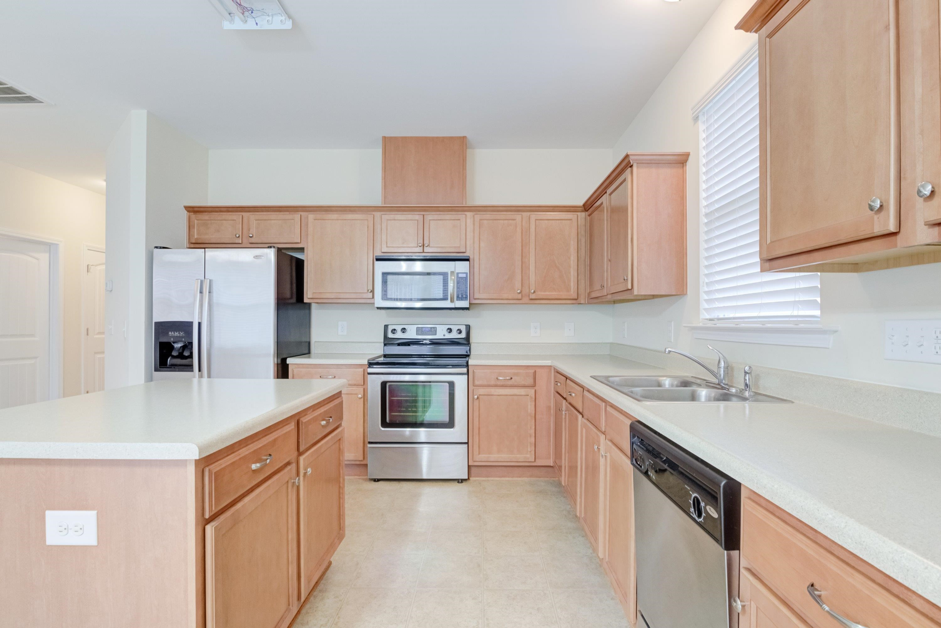 409 Birchrun Drive Durham, NC 27712 - Photo 17 of 49 a kitchen with stainless steel appliances a sink stove refrigerator and cabinets