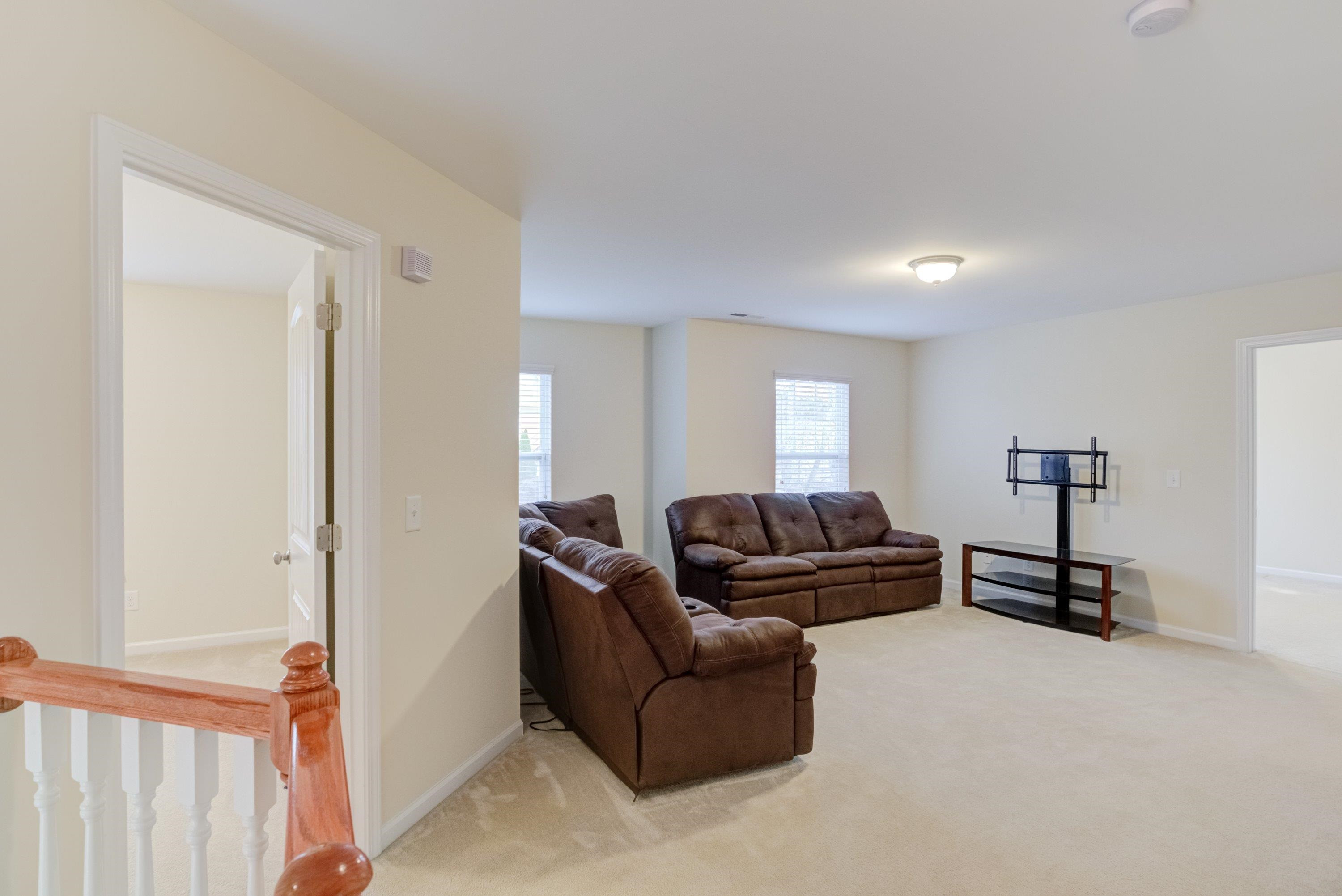 409 Birchrun Drive Durham, NC 27712 - Photo 22 of 49 a living room with furniture a mirror and a wooden floor