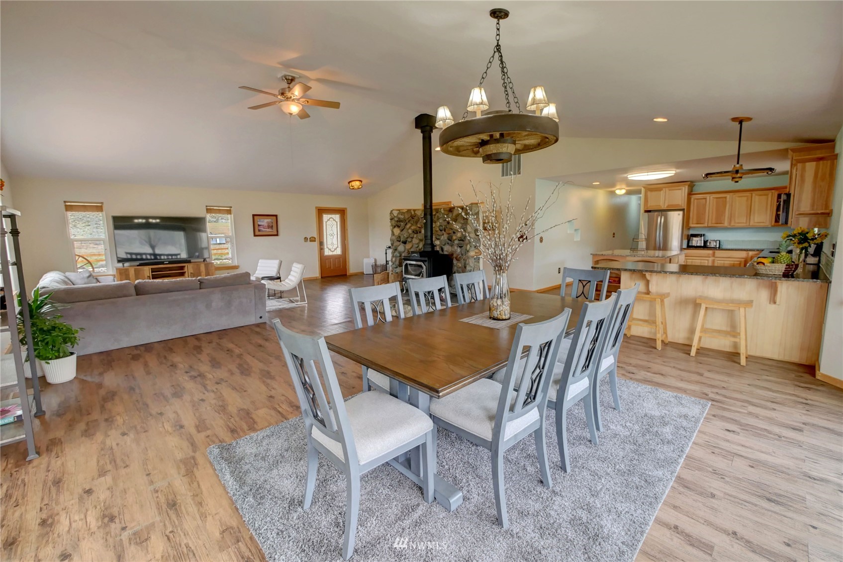 196 Pharr Road Riverside, WA 98849 - Photo 16 of 40 a dining room with wooden floor a chandelier a wooden table and chairs