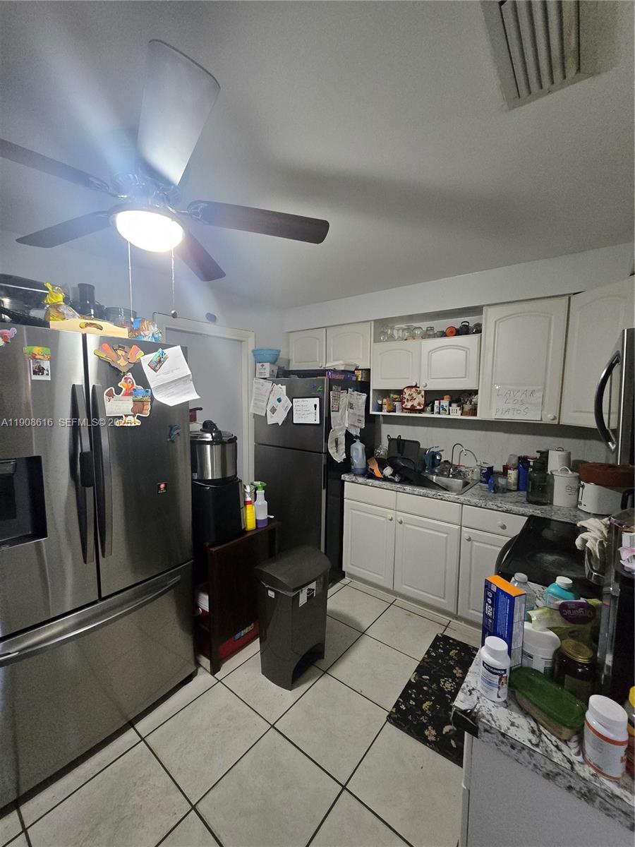 5709 Lincoln Street Hollywood, FL 33021 - Photo 5 of 17 a kitchen with refrigerator and cabinets