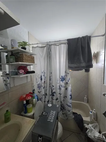 a bathroom with a bathtub a sink and a shower curtain