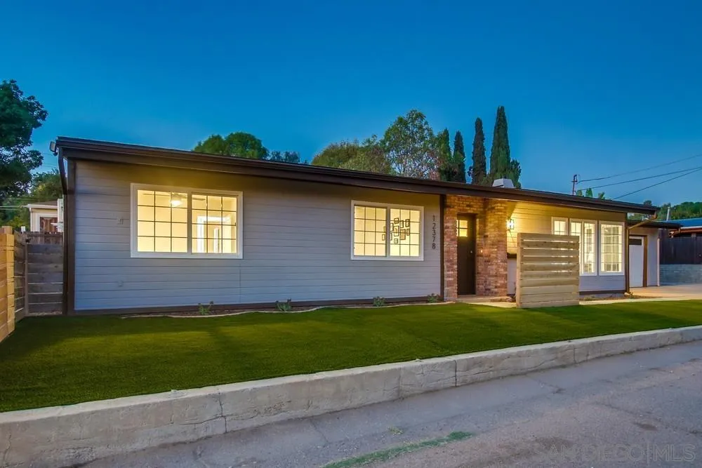 a front view of a house with a garden and yard