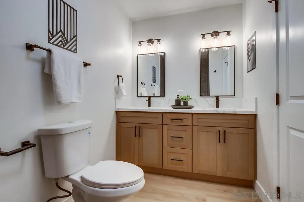 12378 Wade Way El Cajon, CA 92021 - Photo 38 of 48 a bathroom with a toilet a sink a vanity and mirror