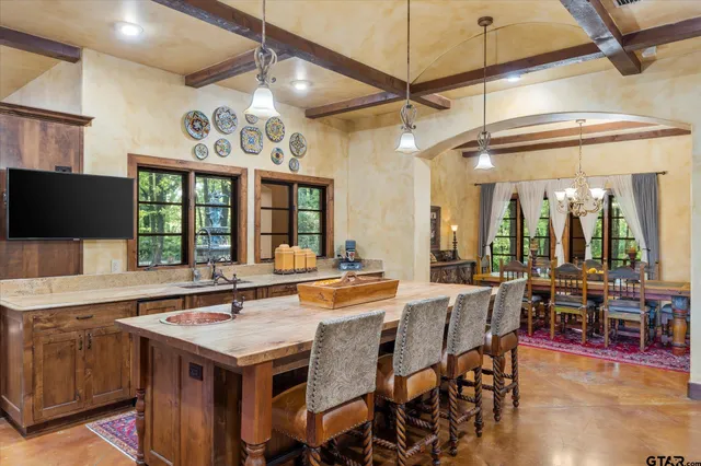 a dining hall with stainless steel appliances granite countertop a sink and a refrigerator