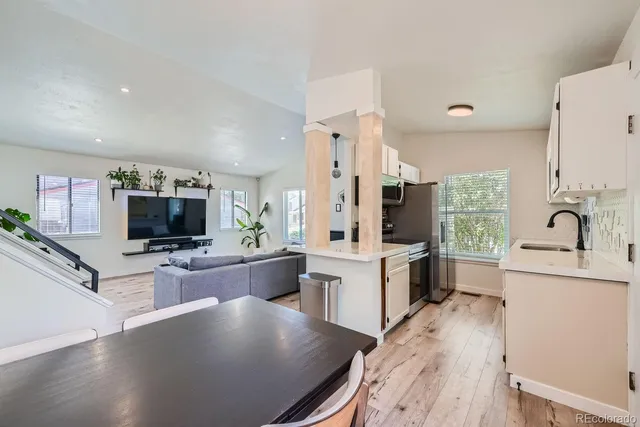 a large white kitchen with a large window and stainless steel appliances