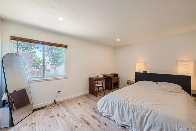 a bedroom with a bed and wooden floor