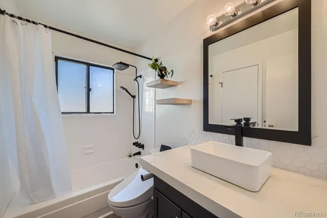 a bathroom with a sink a toilet and a mirror