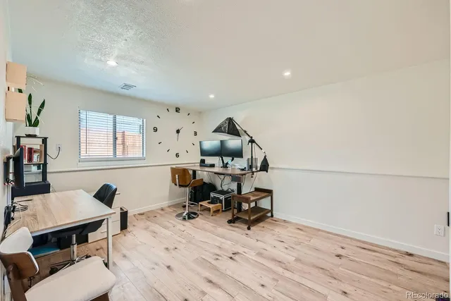 a view of a workspace with furniture and a window