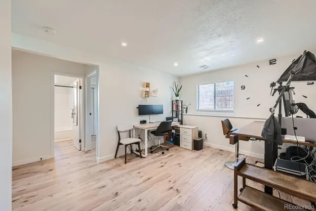 a living room with furniture a flat screen tv and a wooden floor