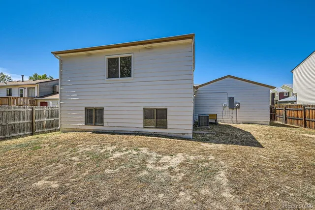 a front view of house with yard and trees in the background