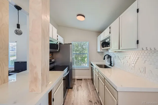 a kitchen with a sink a stove and a microwave