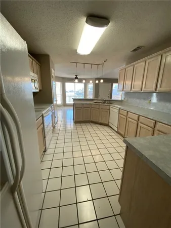 a kitchen with stainless steel appliances a sink a stove cabinets and a dining table