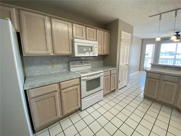 a kitchen with cabinets appliances and a window
