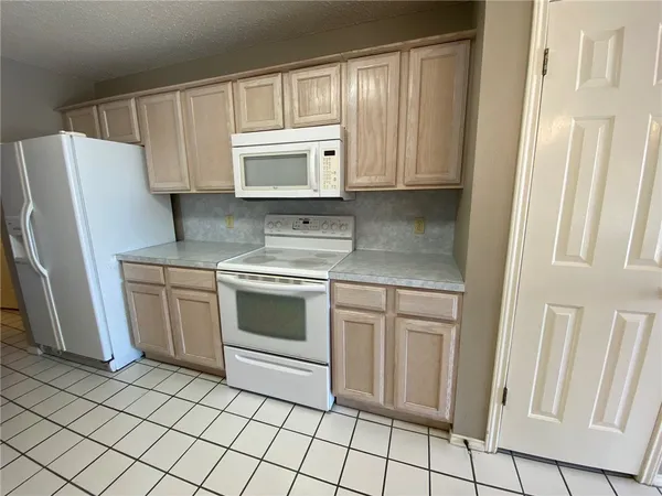 a kitchen with white cabinets and white appliances