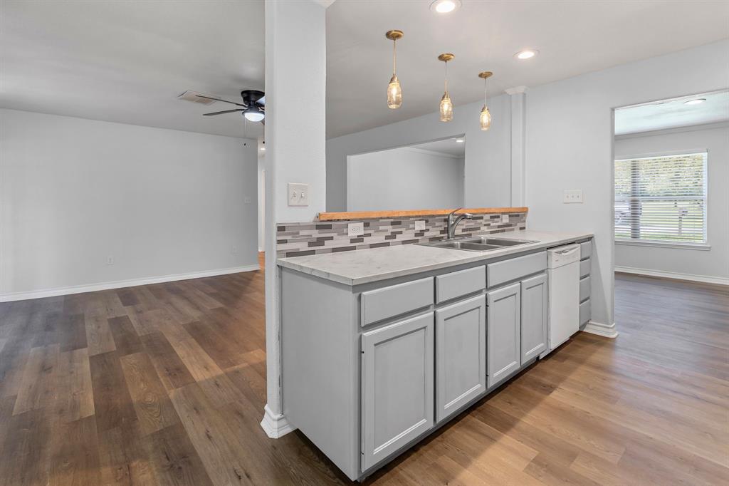 741 Southwest 9th Street Cooper, TX 75432 - Photo 11 of 36 a kitchen with stainless steel appliances granite countertop a stove and a wooden floors
