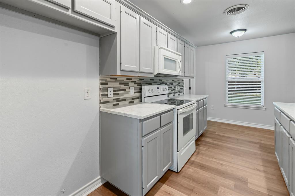 741 Southwest 9th Street Cooper, TX 75432 - Photo 13 of 36 a kitchen with a stove and a white wooden cabinets