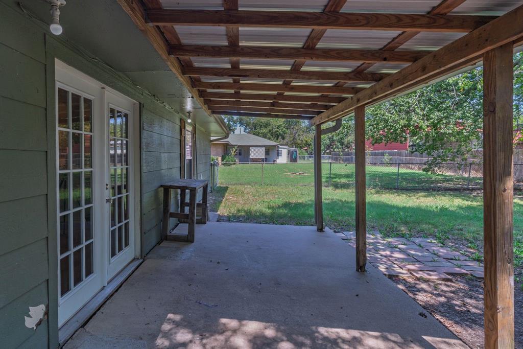 741 Southwest 9th Street Cooper, TX 75432 - Photo 32 of 36 a view of a porch with wooden floor and roof with a garden