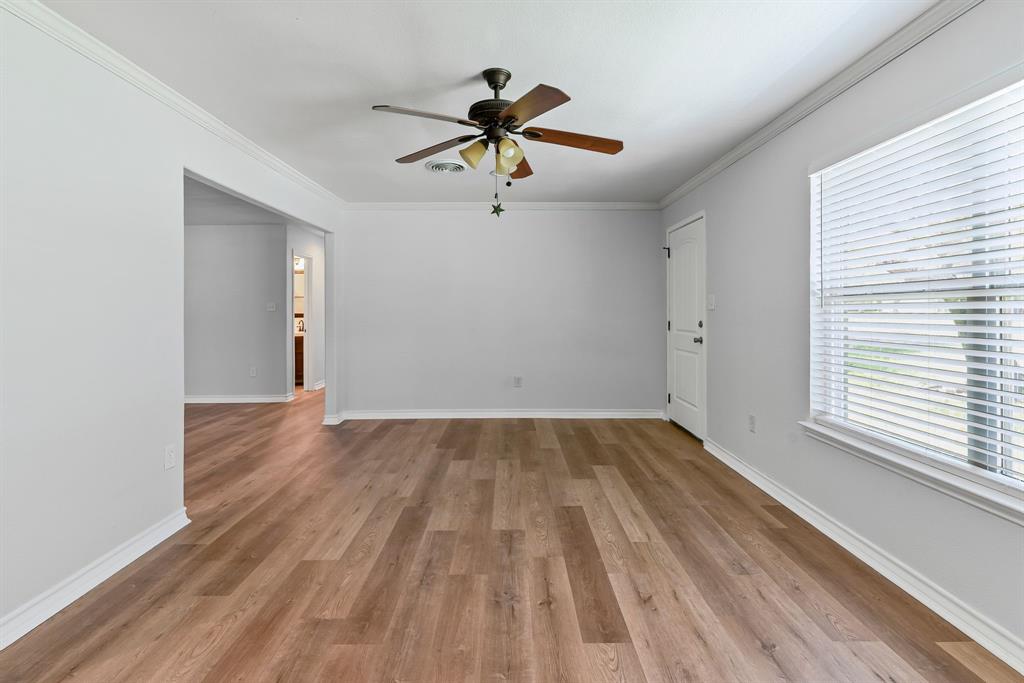 741 Southwest 9th Street Cooper, TX 75432 - Photo 6 of 36 a view of empty room with wooden floor and fan