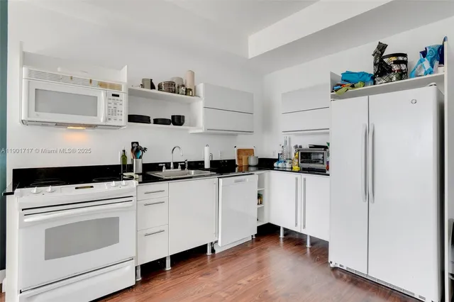 a kitchen with white cabinets and white appliances