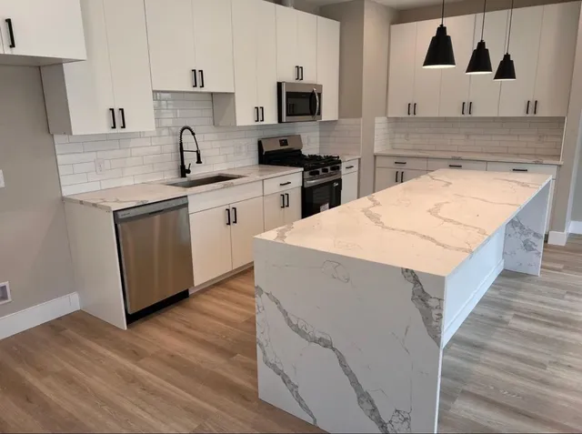 a kitchen with stainless steel appliances granite countertop a sink stove and refrigerator
