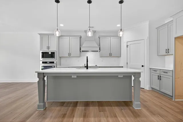 a kitchen with a sink cabinets and wooden floor