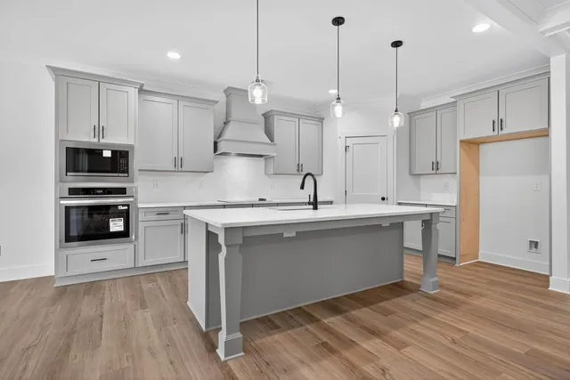 a kitchen with stainless steel appliances kitchen island a white counter space a sink and living room view