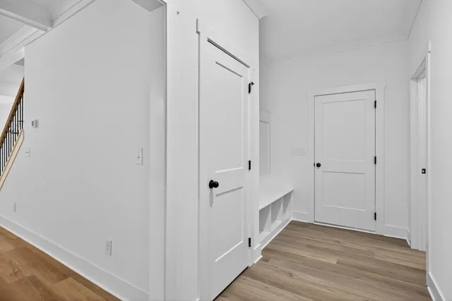 an empty room with wooden floor ceiling fan and windows