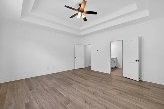 a view of an empty room with wooden floor