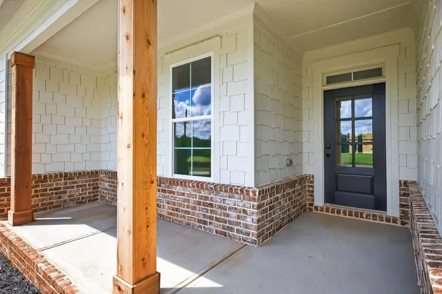 a view of a hallway with wooden floor and a bathroom