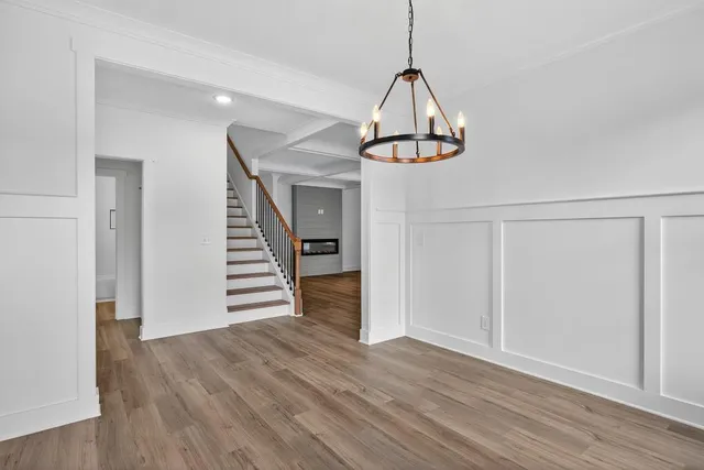 a view of empty room with wooden floor and ceiling fan