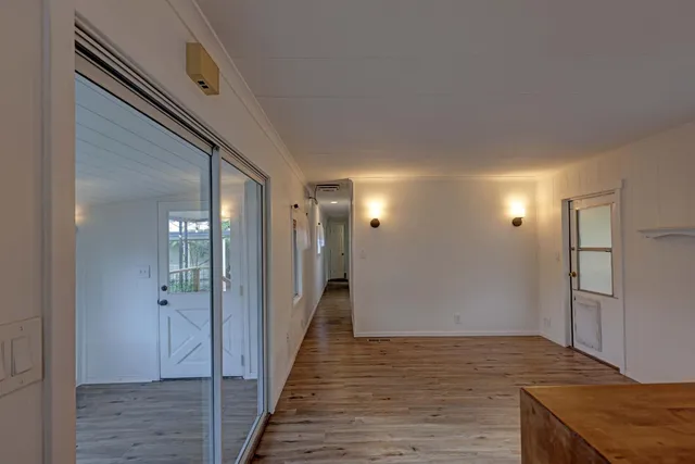a view of a hallway with wooden floor