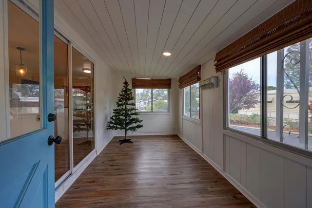 a hallway with wooden floor chandelier and entryway