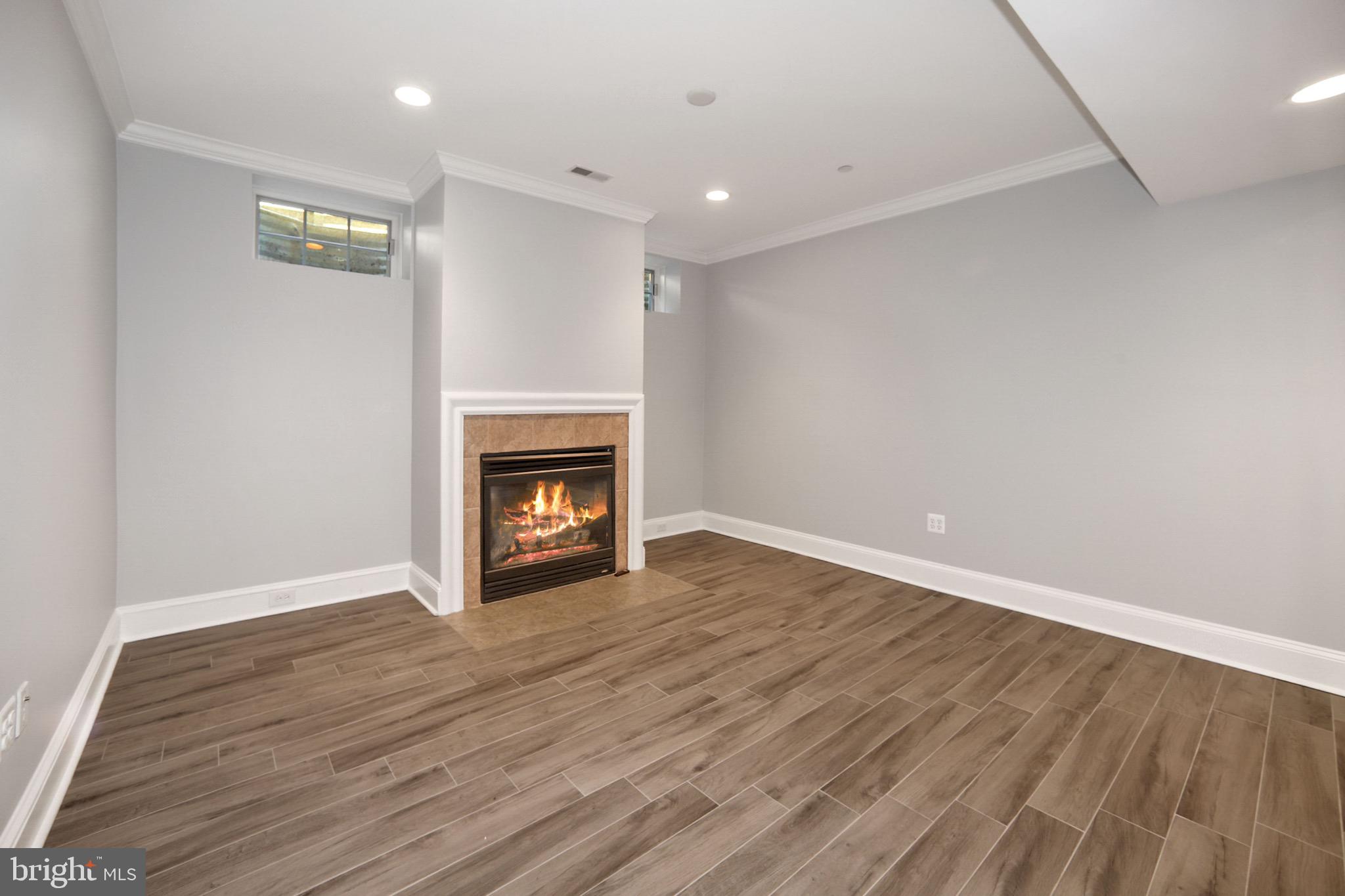 7117 Exfair Road Bethesda, MD 20814 - Photo 37 of 42 a view of an empty room with wooden floor and a fireplace