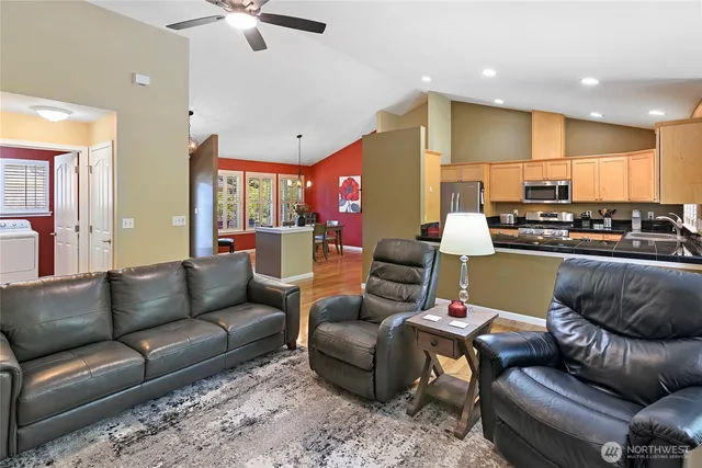 a living room with furniture kitchen view and a chandelier