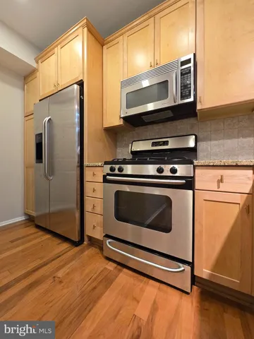 a kitchen with stainless steel appliances a stove a microwave and a refrigerator
