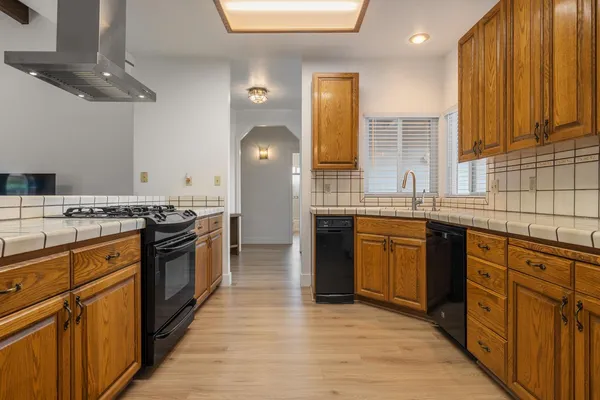 a large kitchen with granite countertop a sink and cabinets