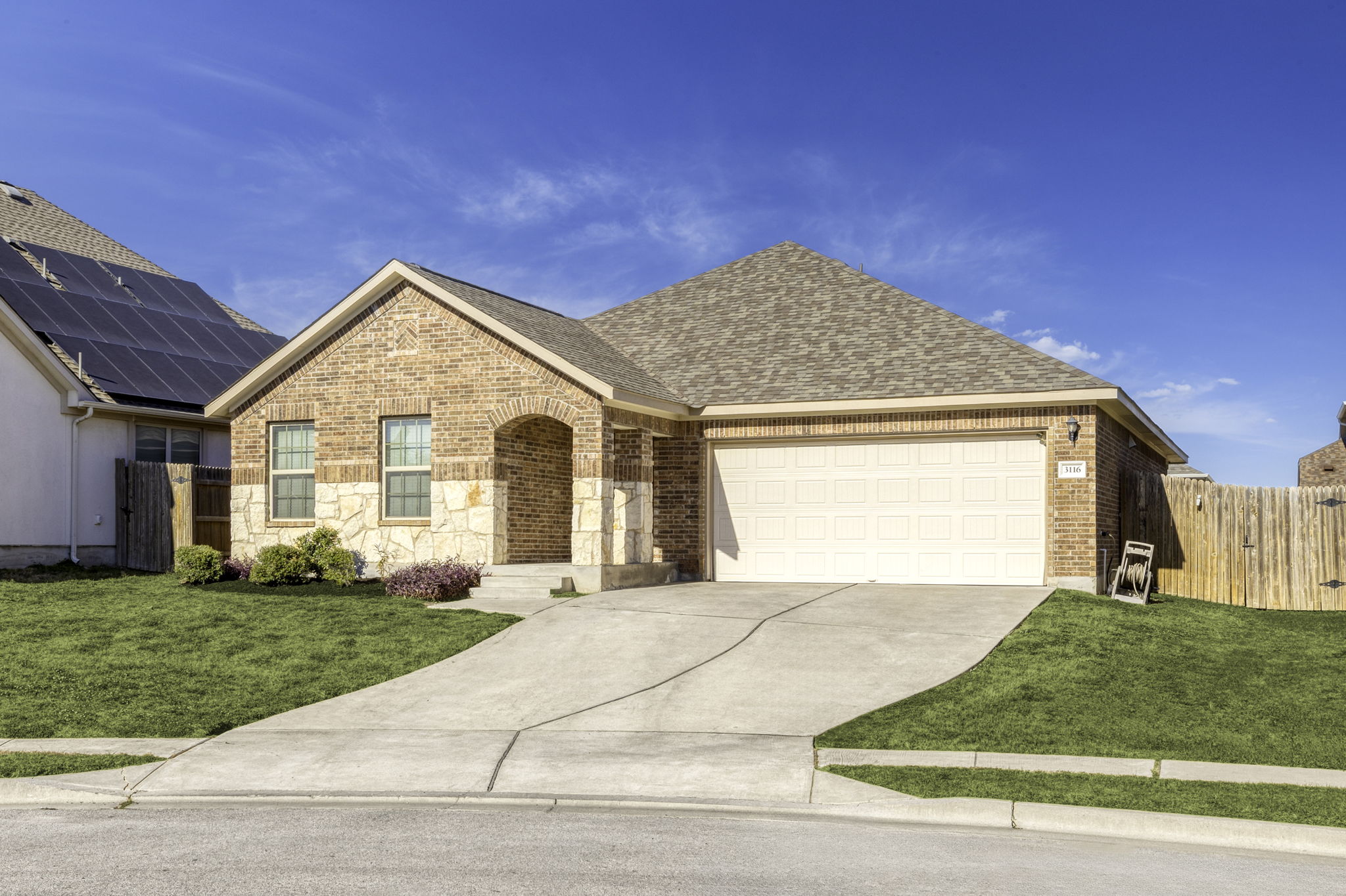 3116 Bragg Place Pflugerville, TX 78660 - Photo 2 of 29 View of front of home featuring roof with shingles, brick siding, concrete driveway, a garage, and stone siding