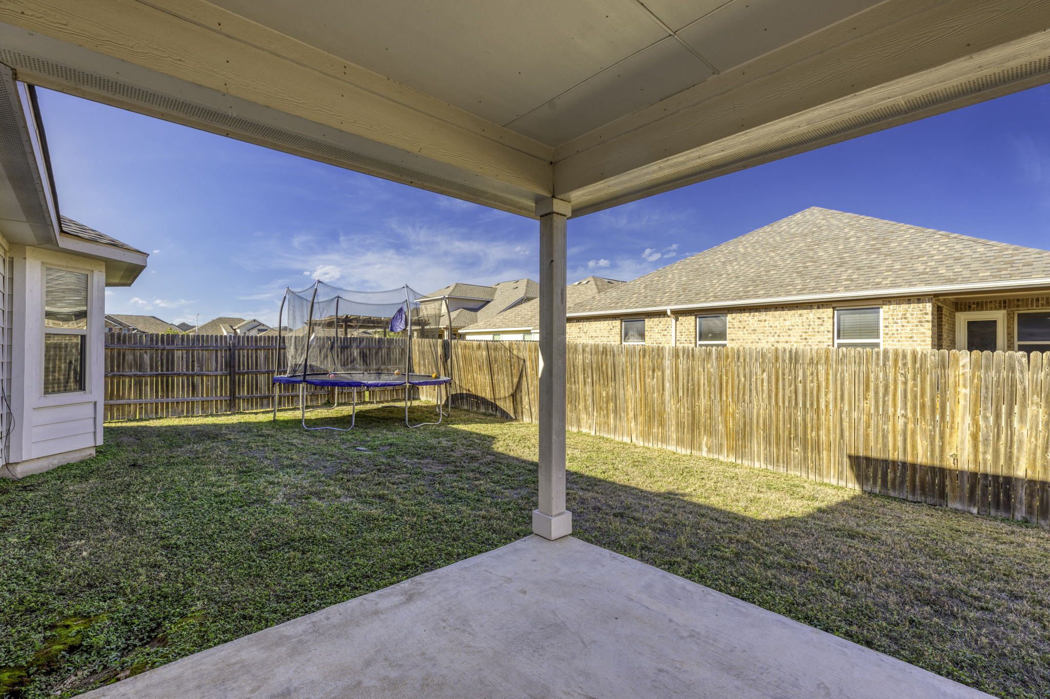 3116 Bragg Place Pflugerville, TX 78660 - Photo 23 of 29 Fenced backyard featuring a trampoline, a patio, and a residential view