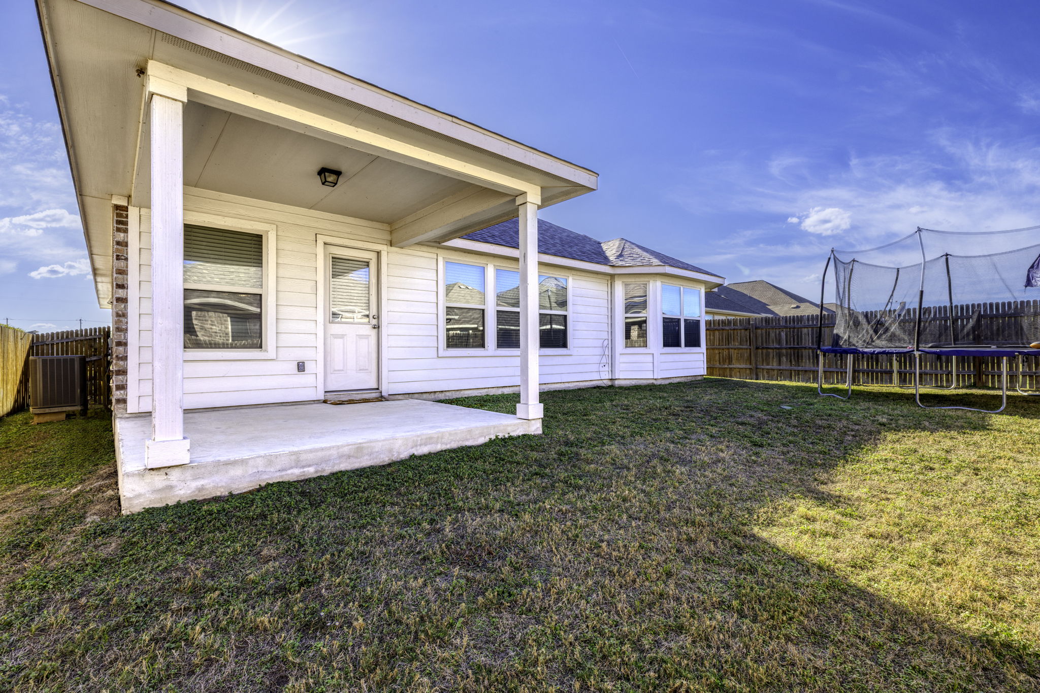 3116 Bragg Place Pflugerville, TX 78660 - Photo 25 of 29 Rear view of property featuring a trampoline, a fenced backyard, and a patio area