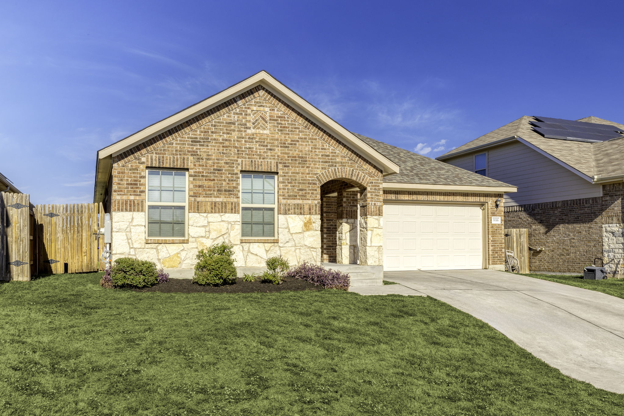3116 Bragg Place Pflugerville, TX 78660 - Photo 3 of 29 View of front facade featuring a shingled roof, an attached garage, concrete driveway, and brick siding