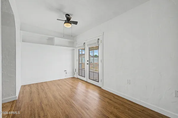 an empty room with wooden floor and windows